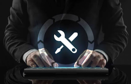 A person typing on a keyboard with a glowing wrench and screwdriver icon hovering above, symbolizing IT support and maintenance tools.